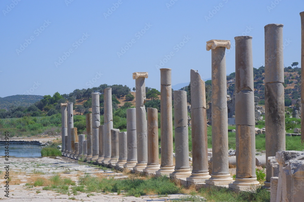  the remains of the ancient ancient temple of the Greek city columns stand in place around the forest hills and blue sky