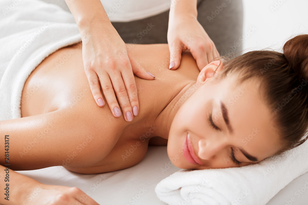 Woman enjoying back and neck massage in the health spa Woman enjoying back and neck massage in the health spa