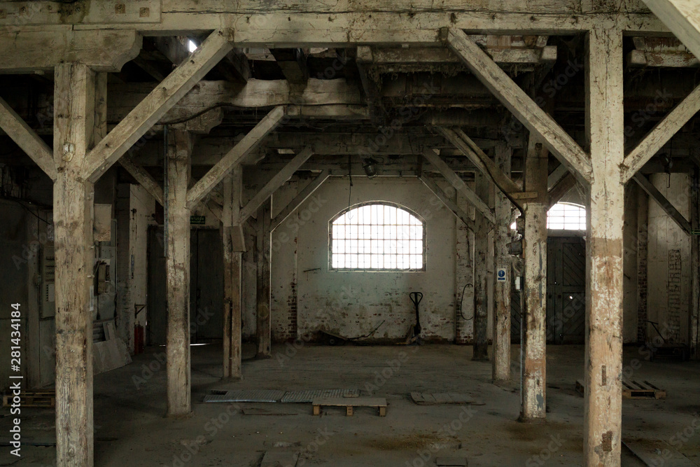 Old wooden columns. Old abandoned warehouse, illuminated by light from the window.