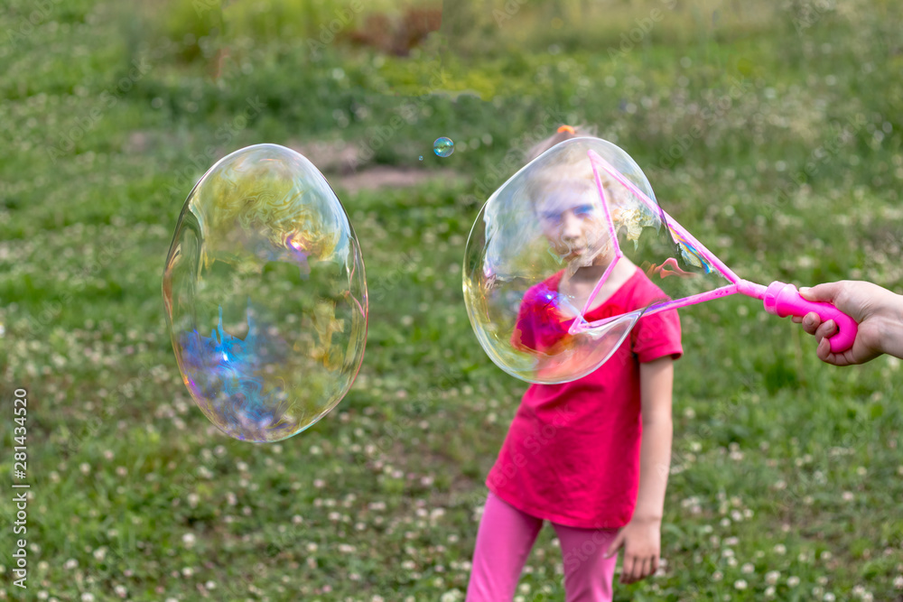 little girl, blonde, playing in the meadow, and blows a bubble. little girl, blonde, playing in the meadow, and blows a bubble.