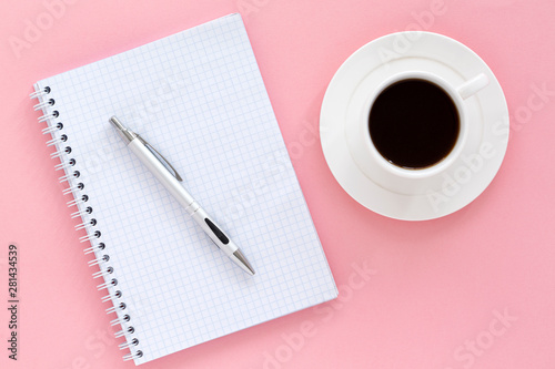 School notebook on a pink background. Blank notepad white page, pen and coffee, color background. Top view, space for text.   
