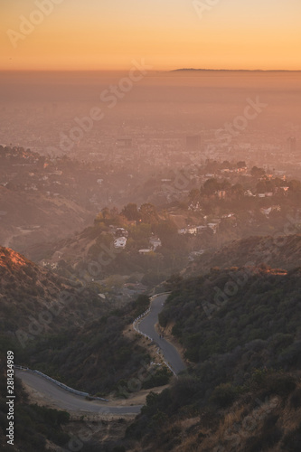 winding road with mountains overlooking the city during sunset los angeles