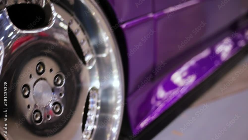 Close up of purple car wheel with custom disk of tuned low rider sport car, toned