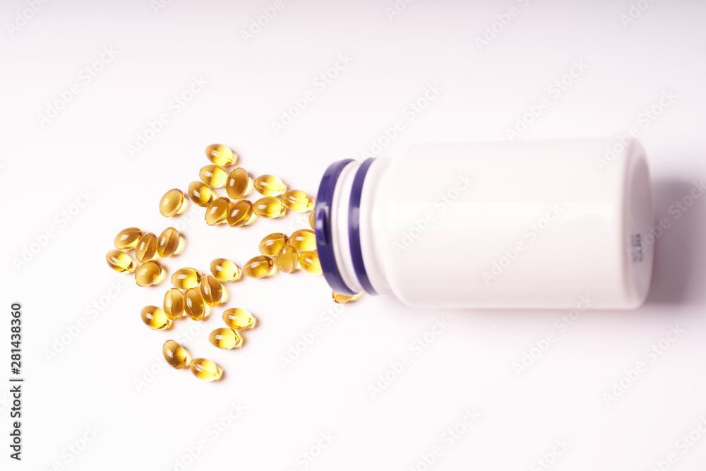 White bottle with scattered vitamins on white background White bottle with scattered vitamins on white background