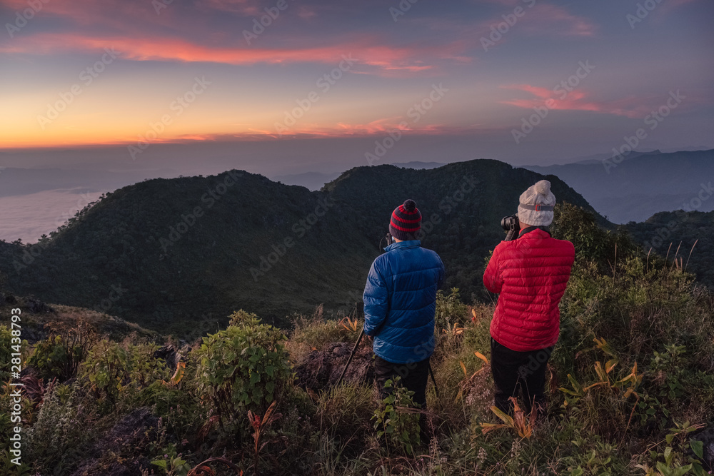 Man travelers take a photo on top of mountain in wildlife sanctuary