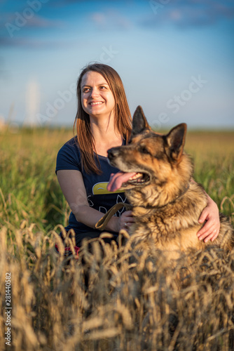 Girl with a dog on a green field. © shymar27