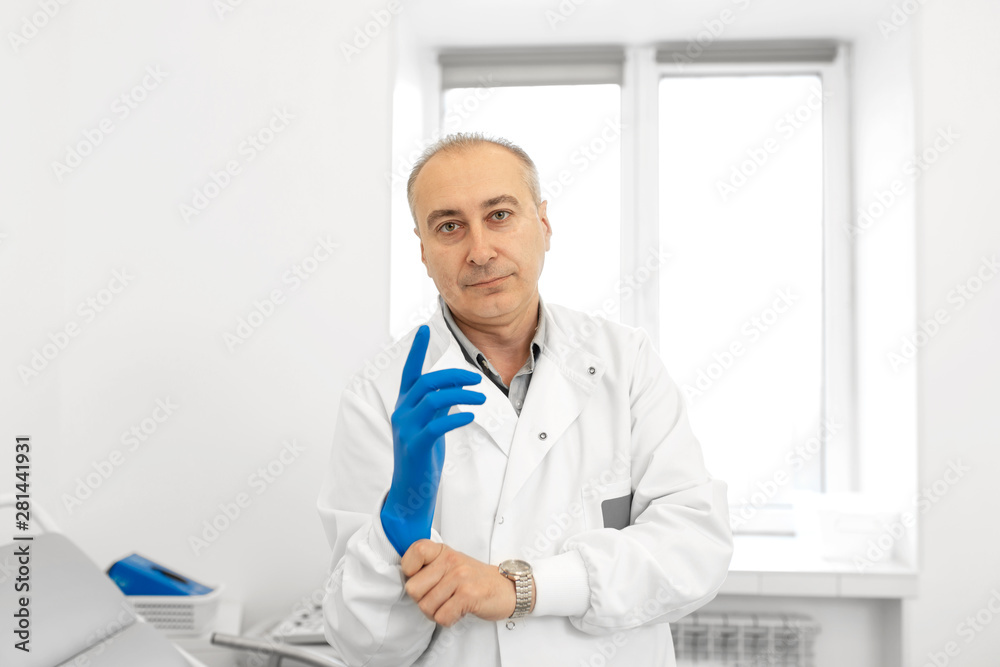Portrait of doctor puts on medical glove Portrait of doctor puts on medical glove