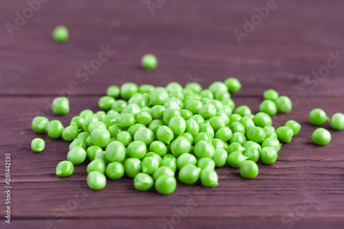 young green peas scattered on a wooden background