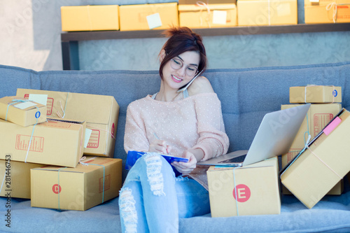 Young business woman working online shopping and talking with customer by her smartphone photo