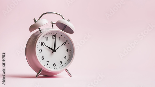 Vintage alarm clock on pink background