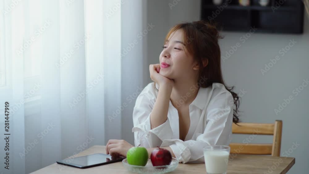 Beautiful woman thought with happily and drink milk in glass Beautiful woman thought with happily and drink milk in glass