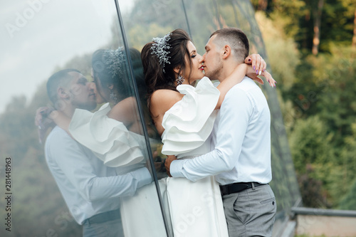Happy groom is is tenderly kissing beautiful bride. Sensual romantic moment. Enjoy moment of happiness and having fun. Concept about passion and love. © Tetiana Moish