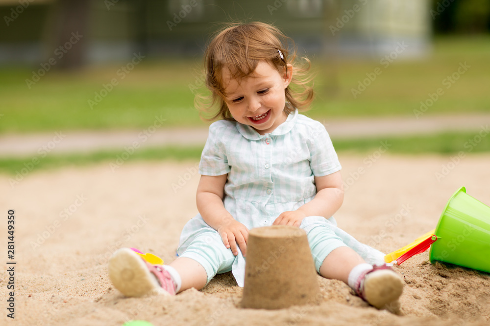 Fototapeta koncepcja dzieciństwa, wypoczynku i ludzi - mała dziewczynka bawi się zabawkami w piaskownicy