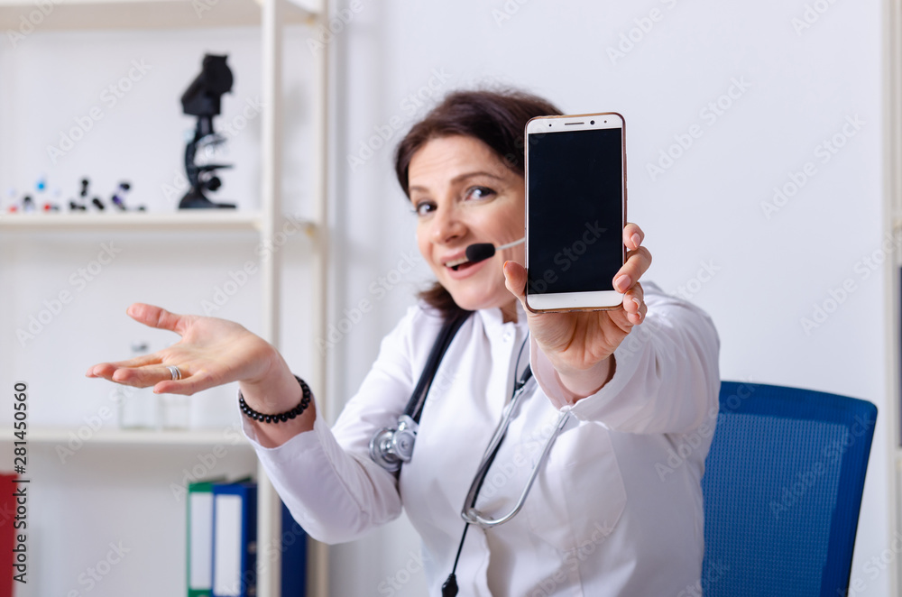 Middle-aged female doctor in telemedicine concept Middle-aged female doctor in telemedicine concept