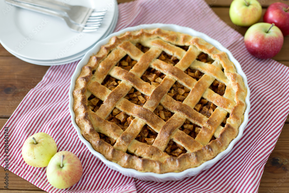 food, culinary and baking concept - apple pie and kitchen towel on wooden table food, culinary and baking concept - apple pie and kitchen towel on wooden table