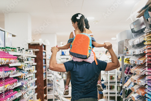 Father and daughter buying school supplies preparing to go back to school, on shoulders