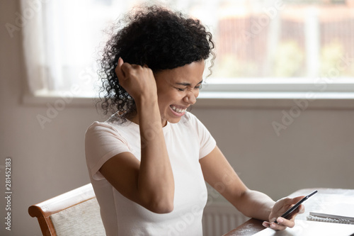 African girl hold phone getting unbelievable news online feels happy