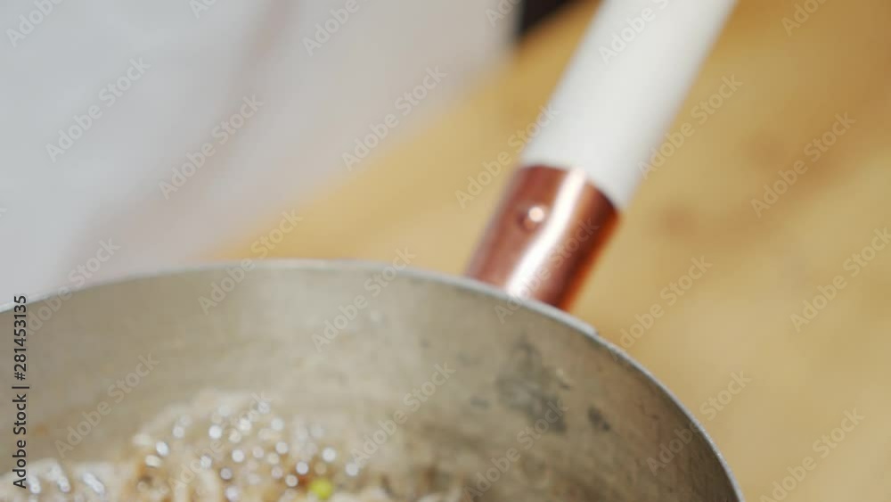 A Japanese female chef cooking Japanese sansho (peppercorn) and sardines at home kitchen, Tokyo, Japan. May 2019. Camera fixed, extreme close-up, high angle. A Japanese female chef cooking Japanese sansho (peppercorn) and sardines at home kitchen, Tokyo, Japan. May 2019. Camera fixed, extreme close-up, high angle.