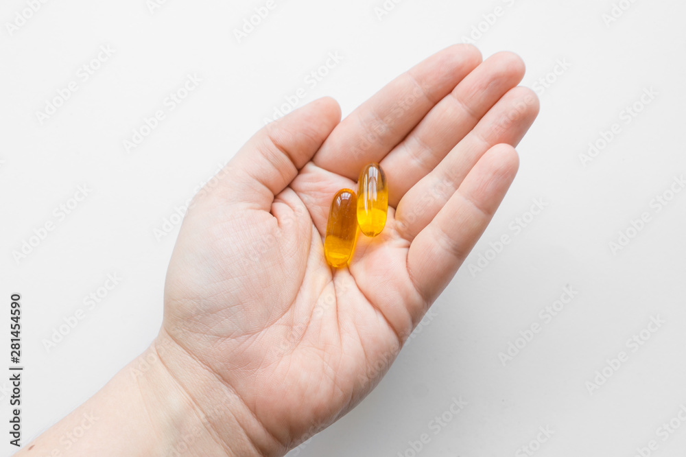 Vitamin capsules with fish oil in the hand. Omega 3-6-9. Vitamin complex. Care of health Vitamin capsules with fish oil in the hand. Omega 3-6-9. Vitamin complex. Care of health