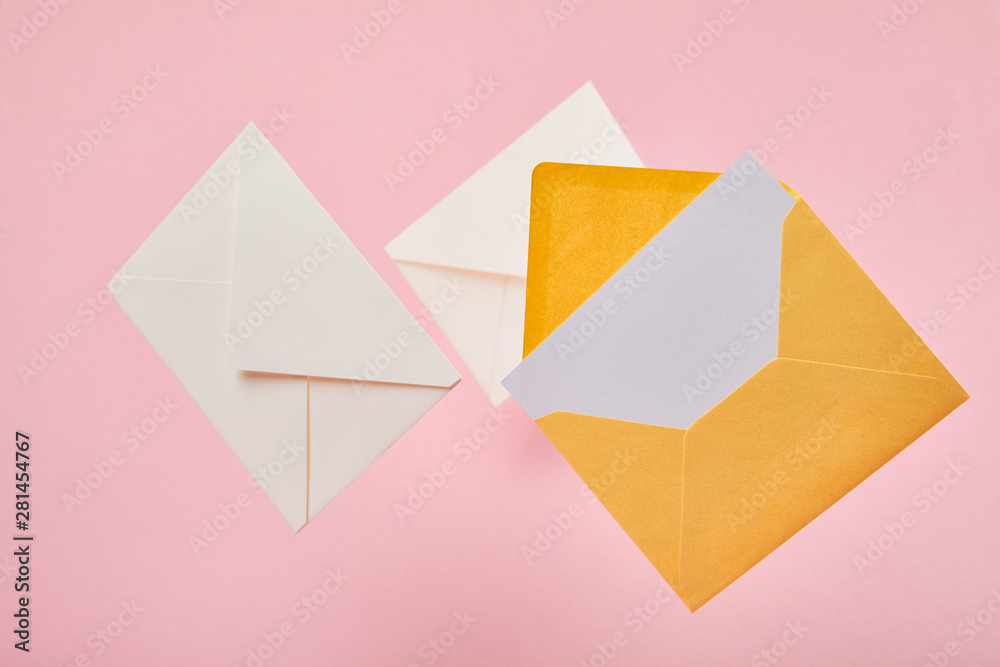 envelopes with blank white card on pink background
