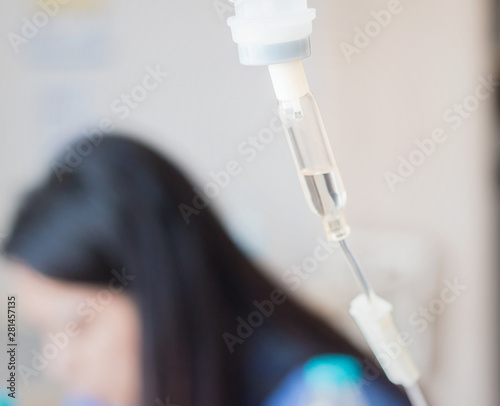Patient woman on hospital bed with IV solution set. Health medical insurance concept.