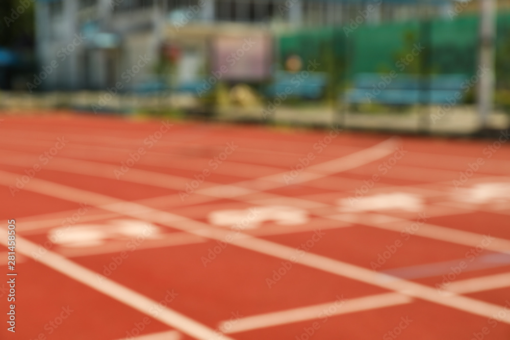 Start of red athletic track with numbers, blurred background