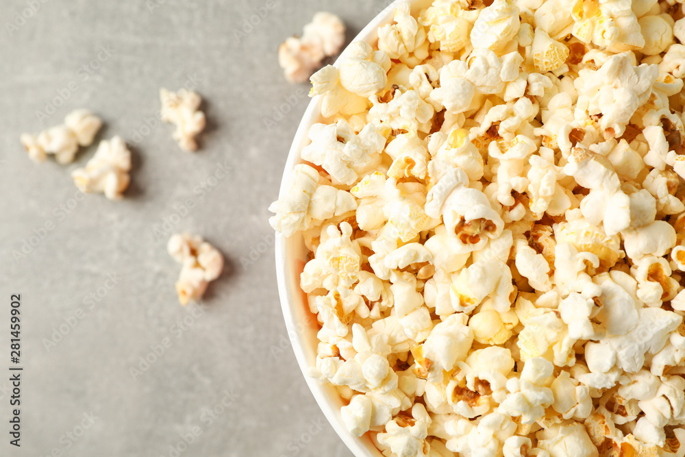 Bucket with popcorn on grey background, space for text