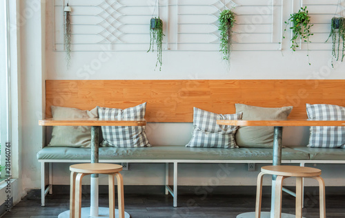 Coffee house interior with wooden table and chairs decorated with hanging bush. Minimal style decoraion. © Wutthikrai