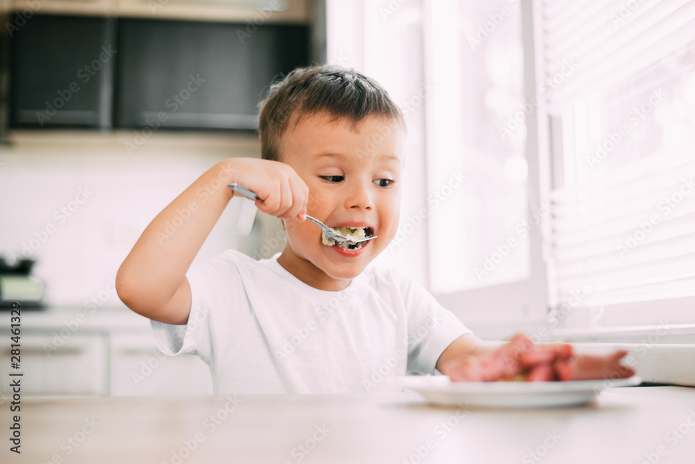 child in the kitchen eating sausage and mashed potatoes child in the kitchen eating sausage and mashed potatoes