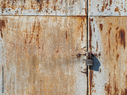 rusty lock hanging on old iron gate