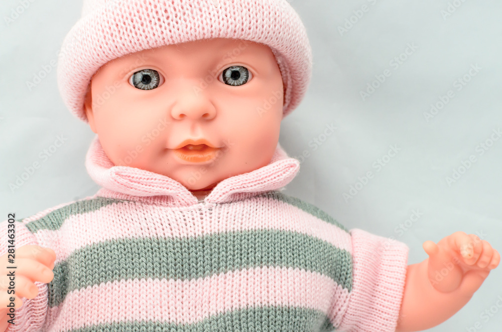 Cute baby doll for girl in knitted dress close up Cute baby doll for girl in knitted dress close up