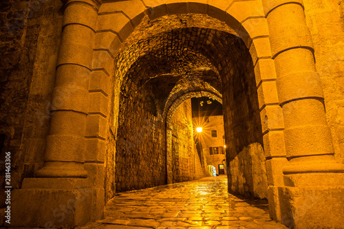 Montenegro, Illuminated narrow alley through old town of kotor bay city by night made of ancient stone