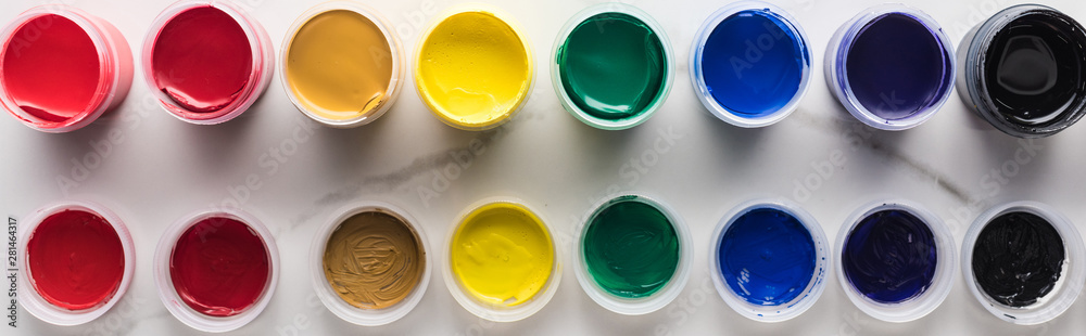 flat lay with multicolored bright gouache paints on marble white surface, panoramic shot flat lay with multicolored bright gouache paints on marble white surface, panoramic shot