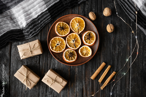 Christmas holiday, round slices of dry orange are on the table near the packed gifts © mtrlin