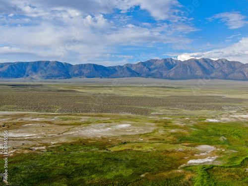 Aerial view of Long Valley next to Mammoth Lakes, Mono County, California. USA. Green grassland with mountain on the background during summer season. 