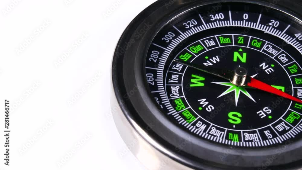 Close up compass rotating on white background. Travel, tourism and exploration Close up compass rotating on white background. Travel, tourism and exploration