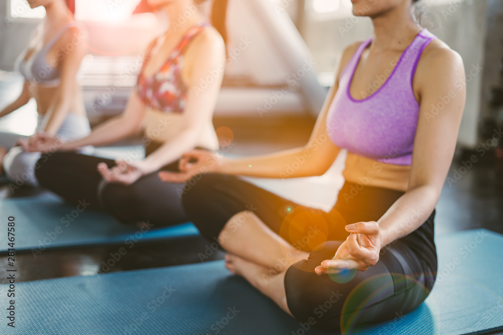 Group of young asian women sporty attractive people practicing yoga lesson with instructor, standing or sitting together in gym.Female friends are doing yoga exercise,working out,studio background. Group of young asian women sporty attractive people practicing yoga lesson with instructor, standing or sitting together in gym.Female friends are doing yoga exercise,working out,studio background.
