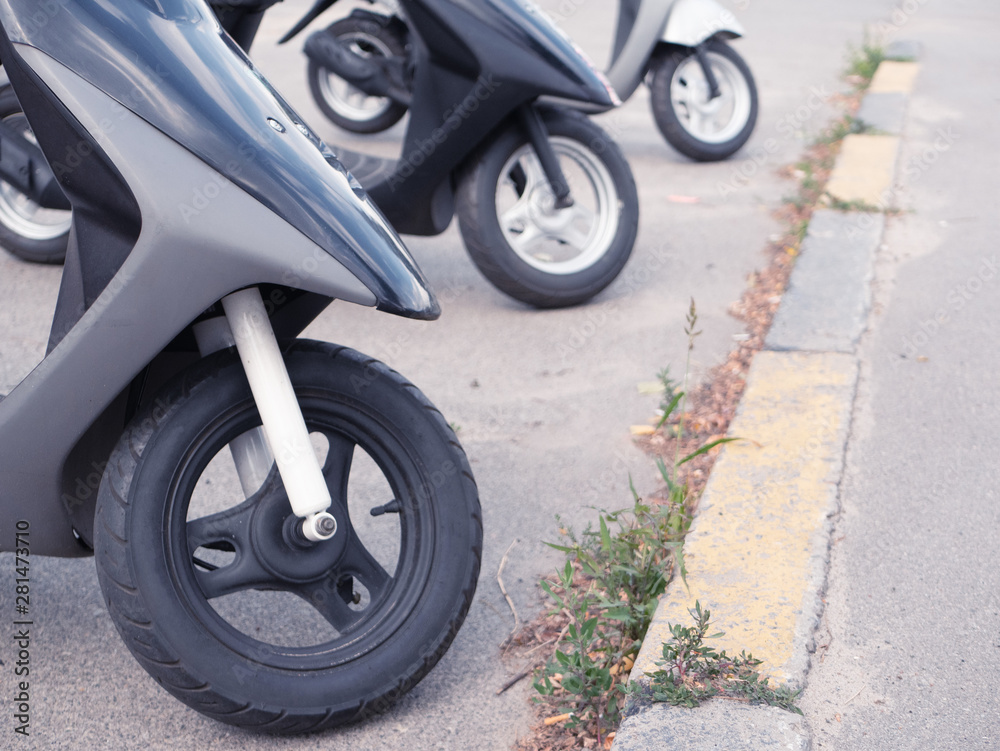 few motobikes on parking near motorcycle store market or rental service. only wheels visible. fast and easy delivery