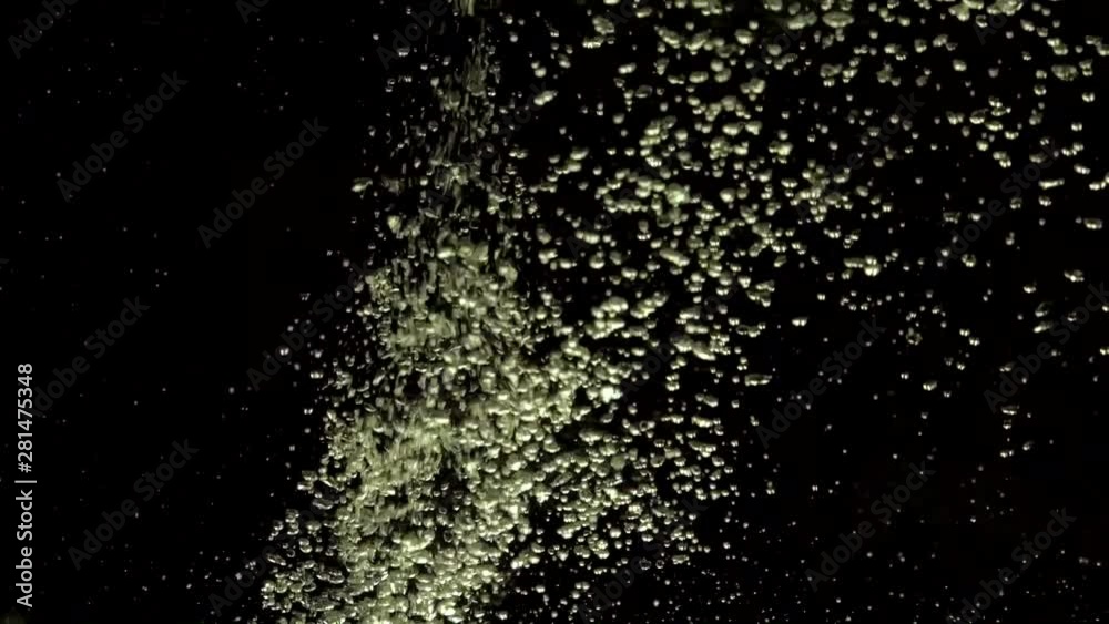 Numerous small air bubbles penetrate under crystal clear water, mixing and rise up, swirling softly underwater on the black background with copy space. Underwater bubbles mayhem. Slow motion. Numerous small air bubbles penetrate under crystal clear water, mixing and rise up, swirling softly underwater on the black background with copy space. Underwater bubbles mayhem. Slow motion.