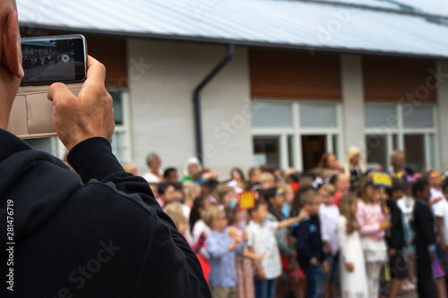 Tumba, Sweden - june.14.2018: A man takes pictures of children on a mobile phone. Circa Salem kommun. photo