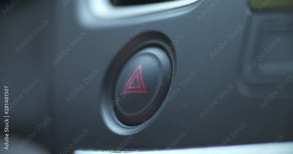Pushing the hazard light button in a vehicle Pushing the hazard light button in a vehicle