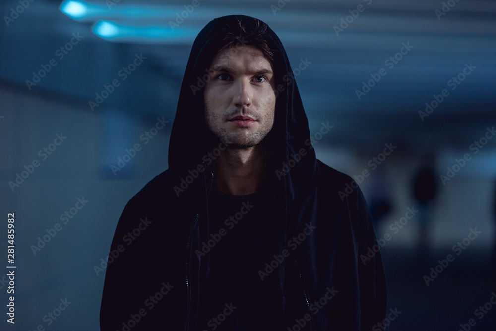 selective focus of handsome thief in black hoodie in underpass selective focus of handsome thief in black hoodie in underpass
