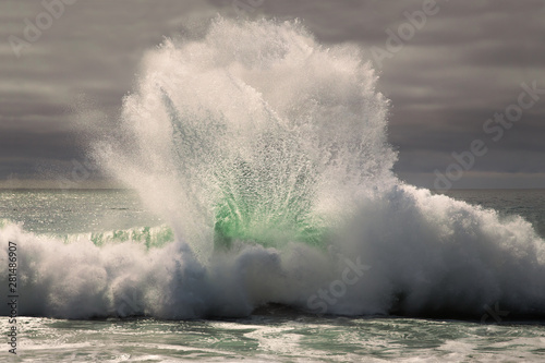 Clam-shaped wave crashing on the beach
