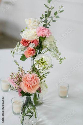 Fototapeta Naklejka Na Ścianę i Meble -  Fresh Flowers in Vase on Table, Wedding Floral Arrangment at Reception, Roses and Peonies in Glass Jars, White Background, Modern Barn Wedding