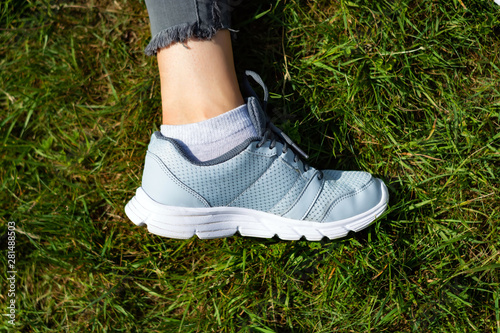 woman's leg in a sneaker is lying on the grass.