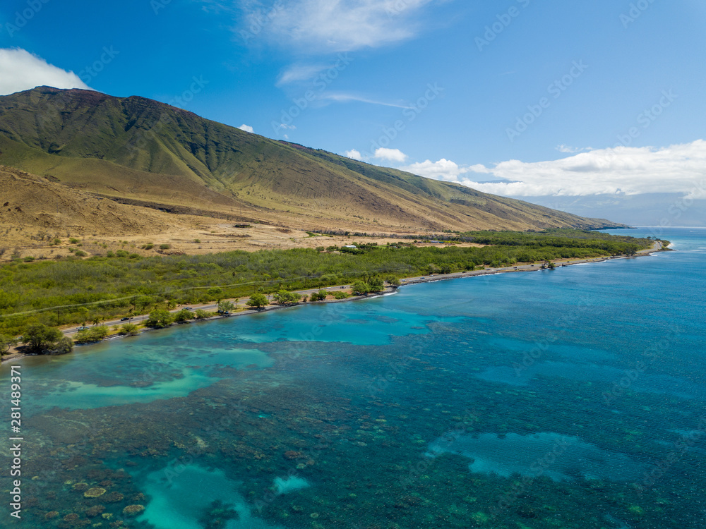 Drone side view of the dry mountains and crystal clear waters of the Lahaina Coast on the island of Maui, Hawaii