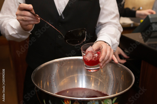 Bartender hand pouring fruit punch in nightclub, bar or pub.