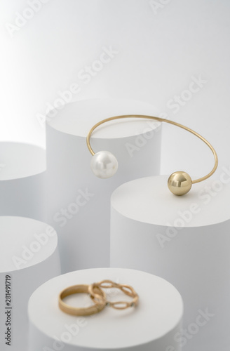 Golden bracelet with pearl on white cylinders and golden rings