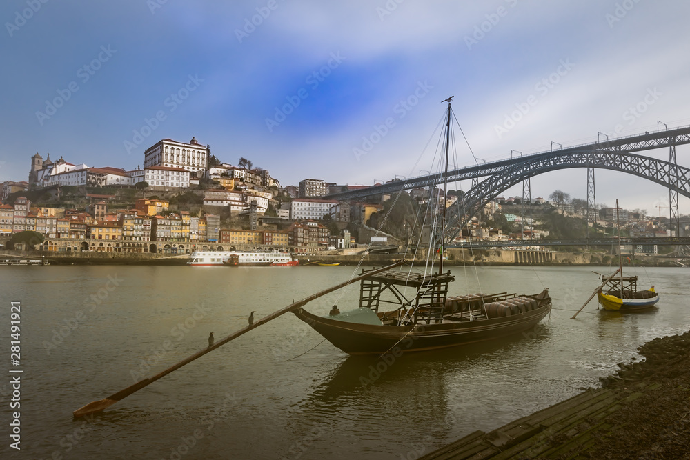 Traditional boats with barrels on the Douro river, Ribeira and Dom Luis bridge, Porto, Portugal.