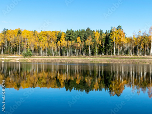 lake view, autumn trees, blue sky with white clouds 